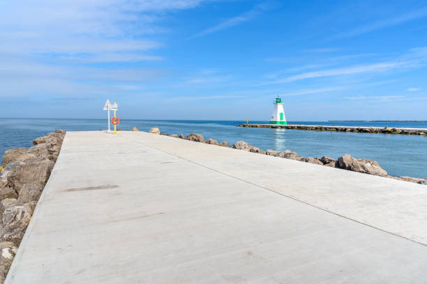 fine di un sentiero di cemento sul frangiflutti all'ingresso di un porto su un lago - sea defence concrete foto e immagini stock