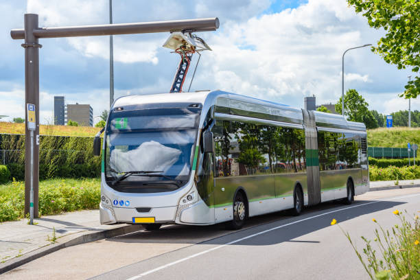 Electric city bus being recharged at a suburban bus stop stock photo