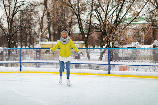 Young adult African woman ice skating