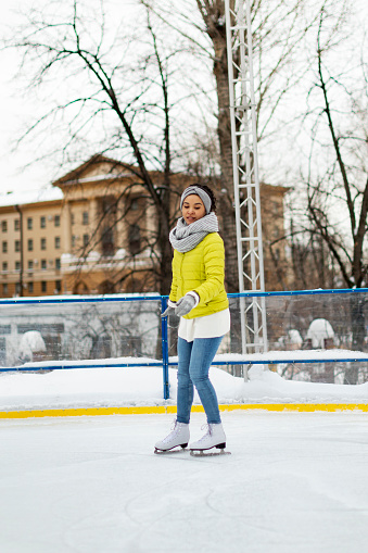 Young adult African woman ice skating
