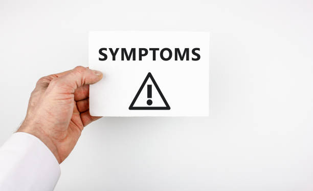 A man holds a sheet in his hand with the inscription SYMPTOMS and an exclamation point in a triangle. The concept of symptoms in the disease. The man holds a sheet in his hand with the inscription SYMPTOMS and an exclamation point in a triangle. The concept of symptoms in the disease. diabetes epidemiology stock pictures, royalty-free photos & images