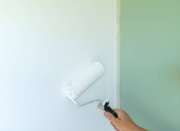 istock Close-up of hand painting the wall with a roller. Copy space. 1423674618