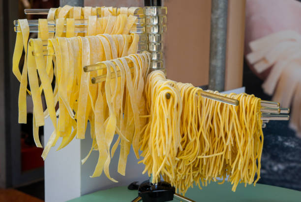 pâtes suspendues sur un séchoir, spaghettis et linguine - pasta noodles tagliatelle freshness photos et images de collection