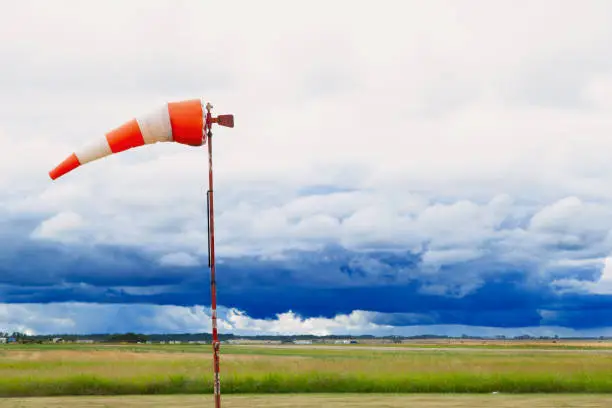 Horizontally flying windsock or wind vane against stormy sky in the background