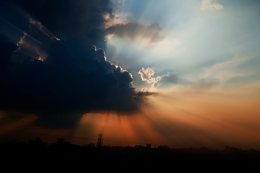 Dramatic sky with beautiful sun rays during springtime landscape close up.