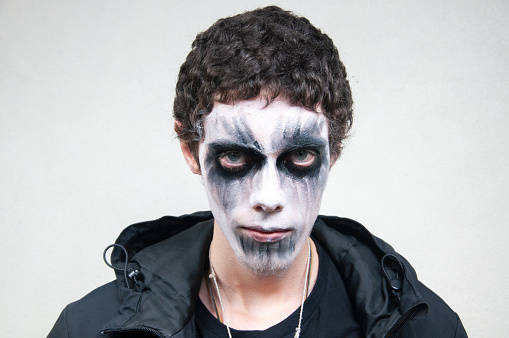 Young man with facial paint on a white background