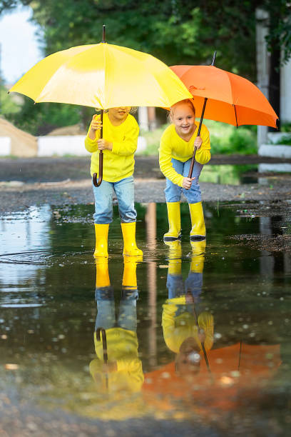 istock children have fun walking through the puddles after the rain 1423688505