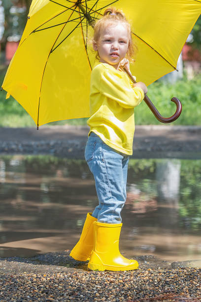 istock children have fun walking through the puddles after the rain 1423688507