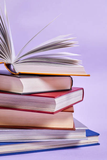 istock Close-up of a stack of books with one open book on top 1423690350