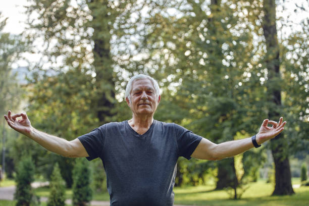 istock Older man do yoga practice in summer park 1423691207