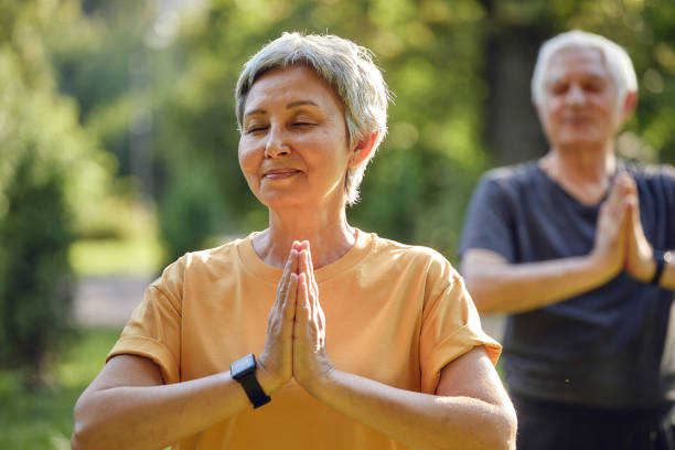 istock Older active couple do meditation practice outdoors 1423691215