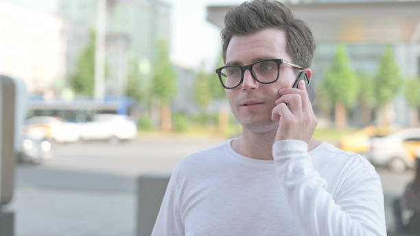 istock Young Man Talking on Phone while Standing Outdoor 1423691876