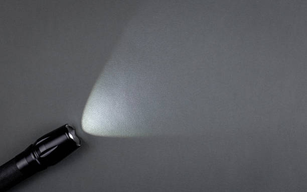 istock A bright beam of light from a flashlight shines on a gray background 1423704334
