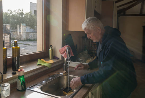 istock Senior men in domestic kitchen washing dishes 1423706016