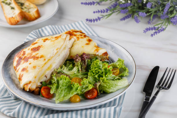 CROQUE MONSIEUR sandwichwith salad, tomato cherry and garlic bread served in a dish isolated on table side view of arabian fastfood stock photo