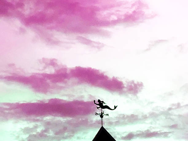 Mermaid Weathervane Silhouetted on an Evening Sky stock photo