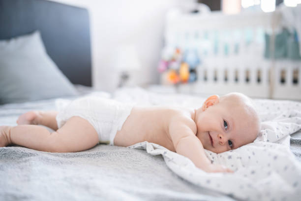 istock Little cute boy laying on front wearing only his diaper. 1423709899