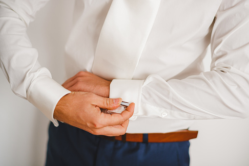 Groom buttoning his shirt