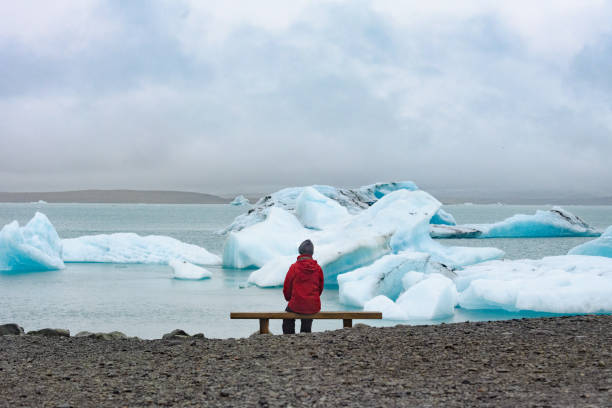 sentado olhando para jökulsárlón islândia - bench winter snow mountain - fotografias e filmes do acervo