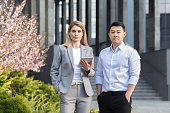 2人の異人種間ビジネスマンの肖像画。オフィスセンターの近くに若い女性とアジア人男性