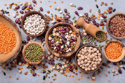 Different beans, lentils, mung, chickpeas in wooden bowls