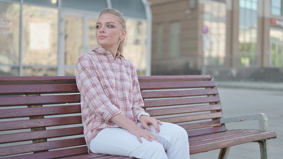Casual Woman Coming and Sitting on Bench Outdoor