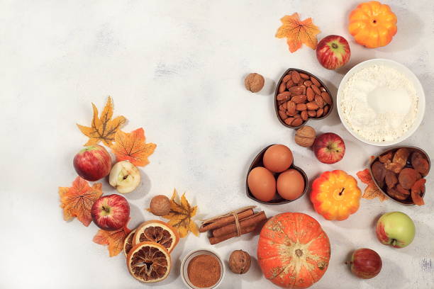 istock Kitchen background with pumpkin, apples, spices, nuts, flour, eggs with place for menu, cooking concept, ingredients for pumpkin and apple pies recipe, 1423730787