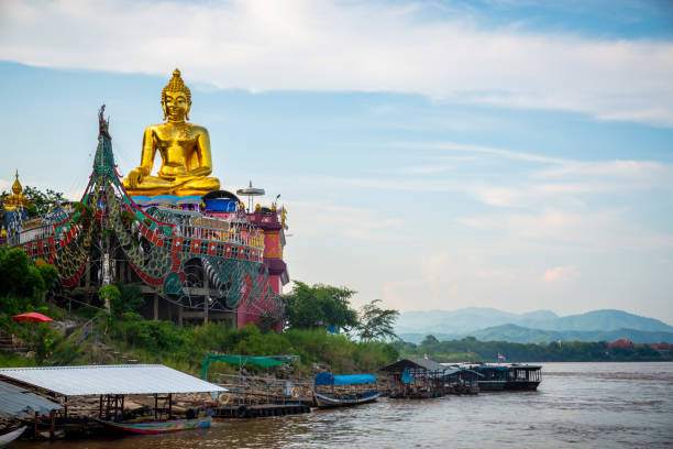 Golden Triangle Buddha monument at Chiang Saen Thailand Golden Seated Buddha in a Boat on the Shore of the Mekong at Phra Chiang Saen Si Phaendin Temple. Laos and Myanmar in the background chiang rai province stock pictures, royalty-free photos & images