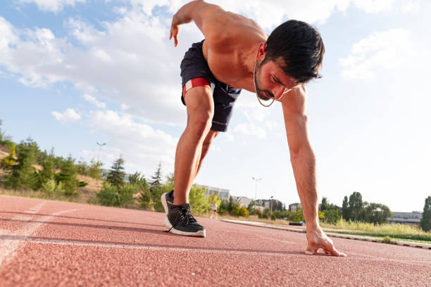 istock Runner using starting block to start his run on running track in a stadium. athlete starting his sprint on an all-weather running track. 1423734153