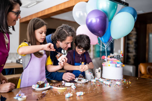 istock Siblings opening and playing with sweets on a children's present with parents at home 1423734589