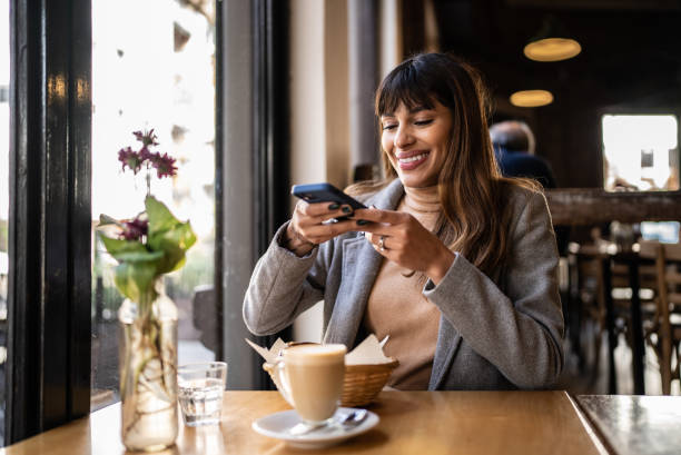 młoda kobieta robiąca zdjęcie chleba tostowego i cappuccino w kawiarni - foodie zdjęcia i obrazy z banku zdjęć