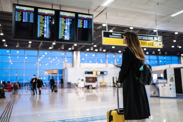 若い女性の空港 - arrival departure board airport travel business travel ストックフォトと画像