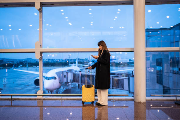 istock Young woman using the mobile phone in the airport 1423740802