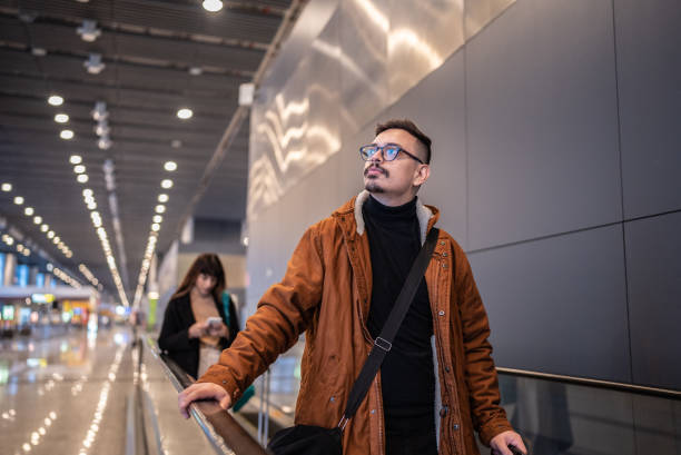 молодой человек в аэропорту - moving walkway escalator airport walking стоковые фото и изображения