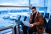 Young man using the laptop in the airport