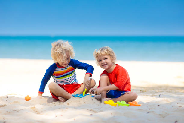 kinder spielen am strand. kinder spielen auf see. - lifestyles child beach digging stock-fotos und bilder