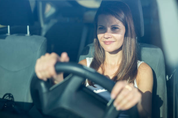 istock Front view of young woman driving car 1423748944