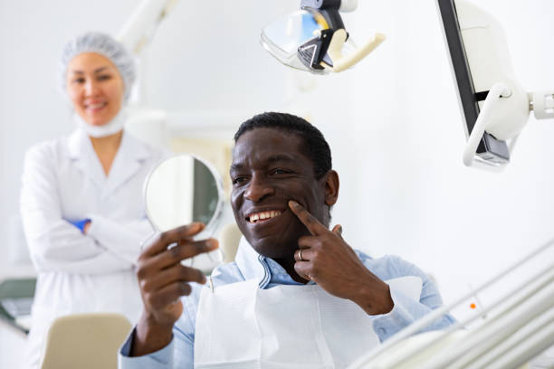istock African american patient checks cured teeth with mirror 1423749020