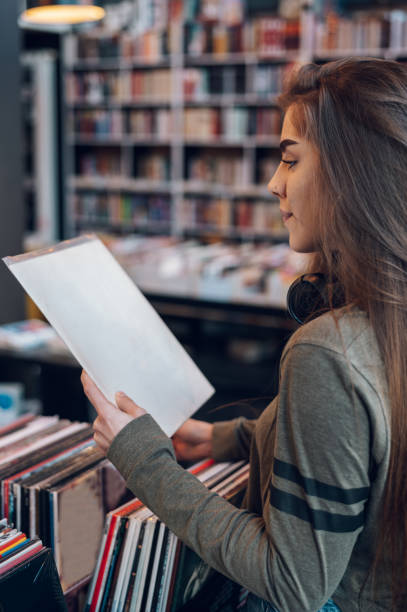 istock Woman holding vinyl while choosing record in a music shop. 1423749621