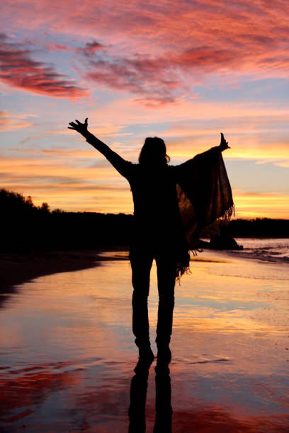 woman walking happily on the beach at sunset - black blue escape multi colored imagens e fotografias de stock