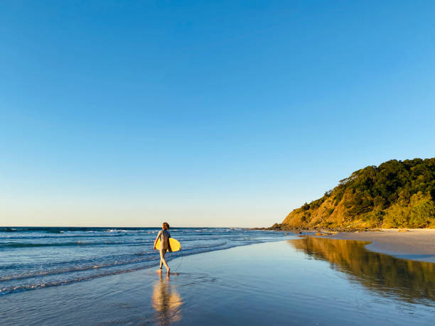 Surfer Walking at Wategos Beach stock photo