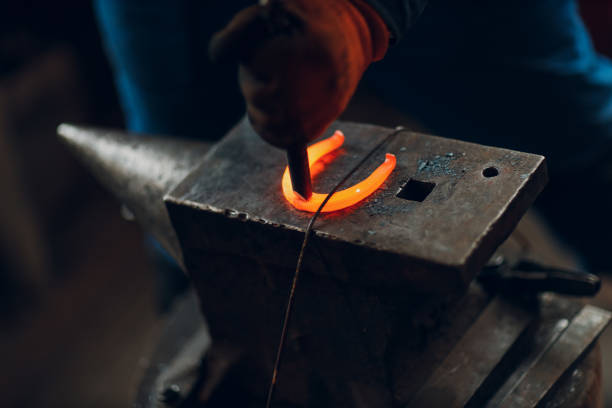 istock Blacksmith forges and makes metal detail with hammer and anvil at forge 1423766206