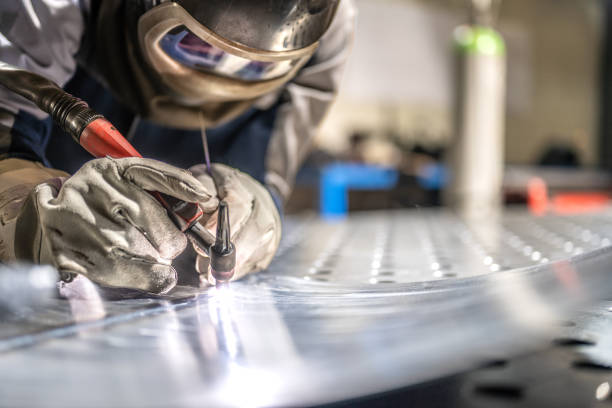 Thin steel sheets welding Close-up view of thin steel sheets welding. Selective focus. People working in engineering industrial production. welding mask stock pictures, royalty-free photos & images