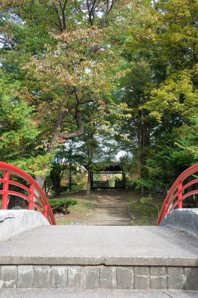 istock Red arch bridge and pavilion in the park 1423768484