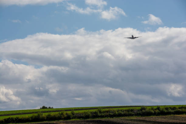 istock Jet airliner flying through green upland fields 1423769087