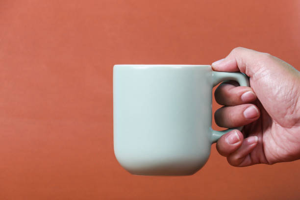istock hand holding coffee cup with copy space for design wood grain vintage background 1423769763