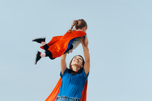 Mom lifting her little child up in aspirational dream imagery