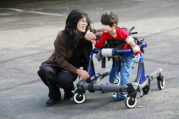 Madre con figlio disabile walker aperto in - foto stock