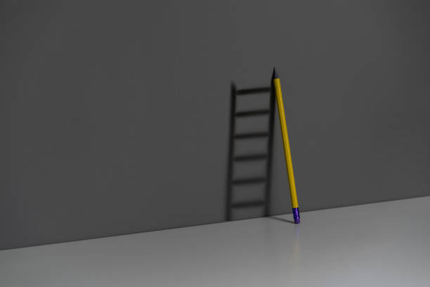istock pencil leaned on the wall and creating ladder made of shadow 1423794170