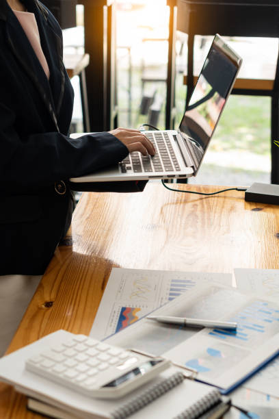 istock Businessman analyzing finances with documents, graphs, accounts and laptop computers. calculator on the desk in the office vertical picture 1423794175